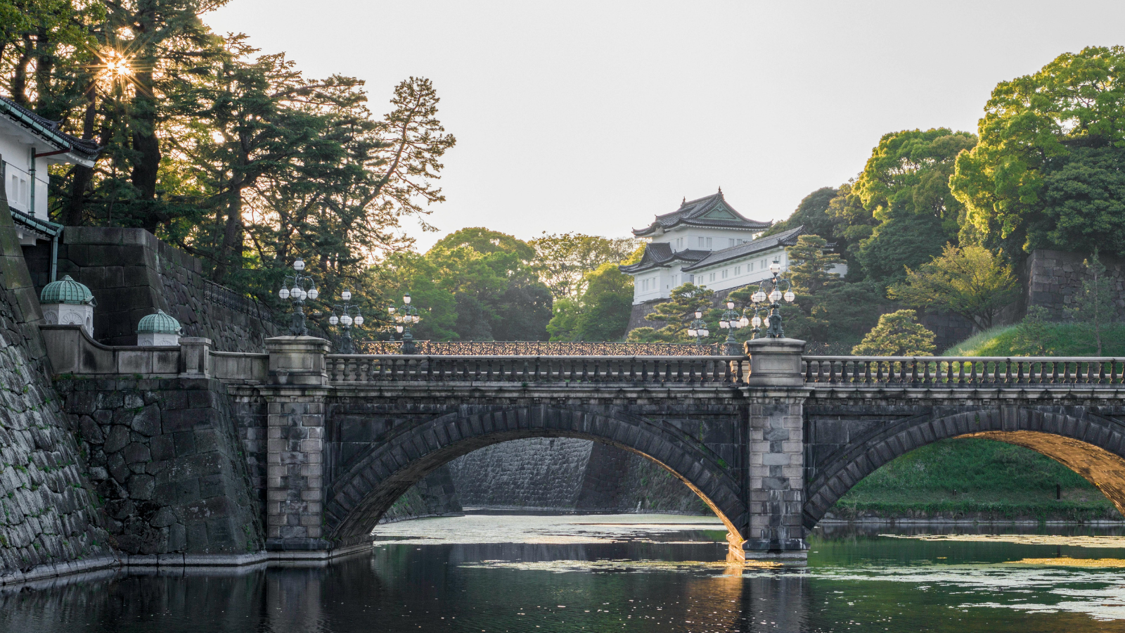 The illuminated modern skyline reflecting beautifully in the serene waters of the Imperial Palace moat